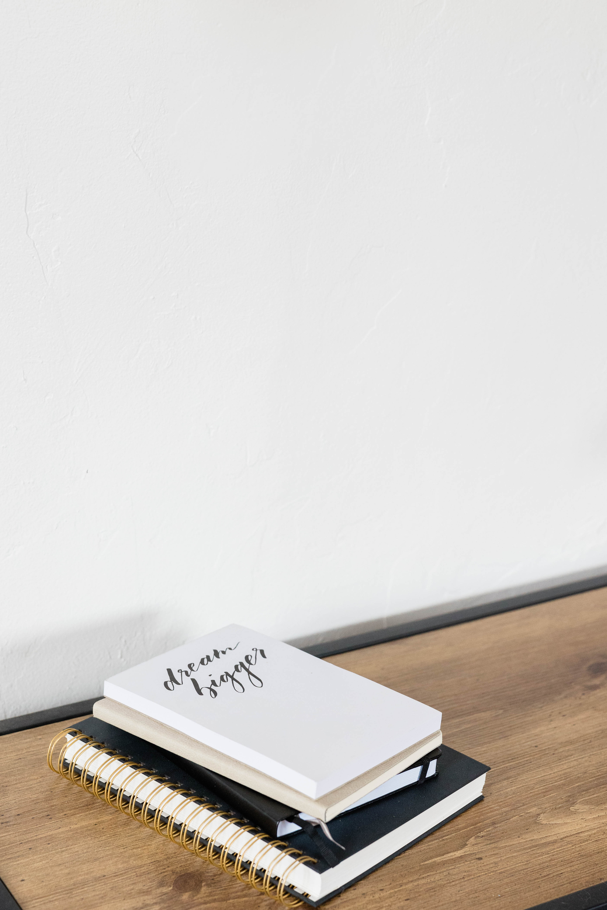 Stack of Notebooks on Wooden Desk